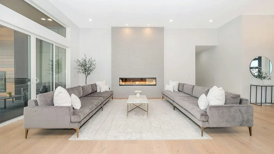 Bright modern living room with large windows and open floor plan, representing residential air purification needs