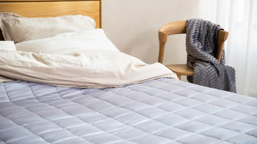 Close-up of fitted sheet corner securing snugly around mattress corner in bedroom setting