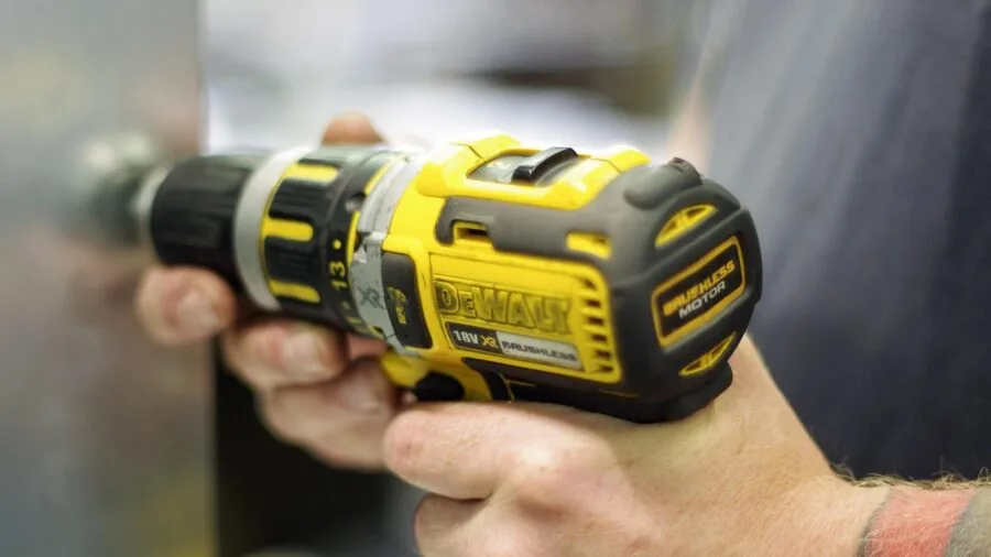 DIY enthusiast operating a cordless drill while working on a wooden project in a home workshop setting