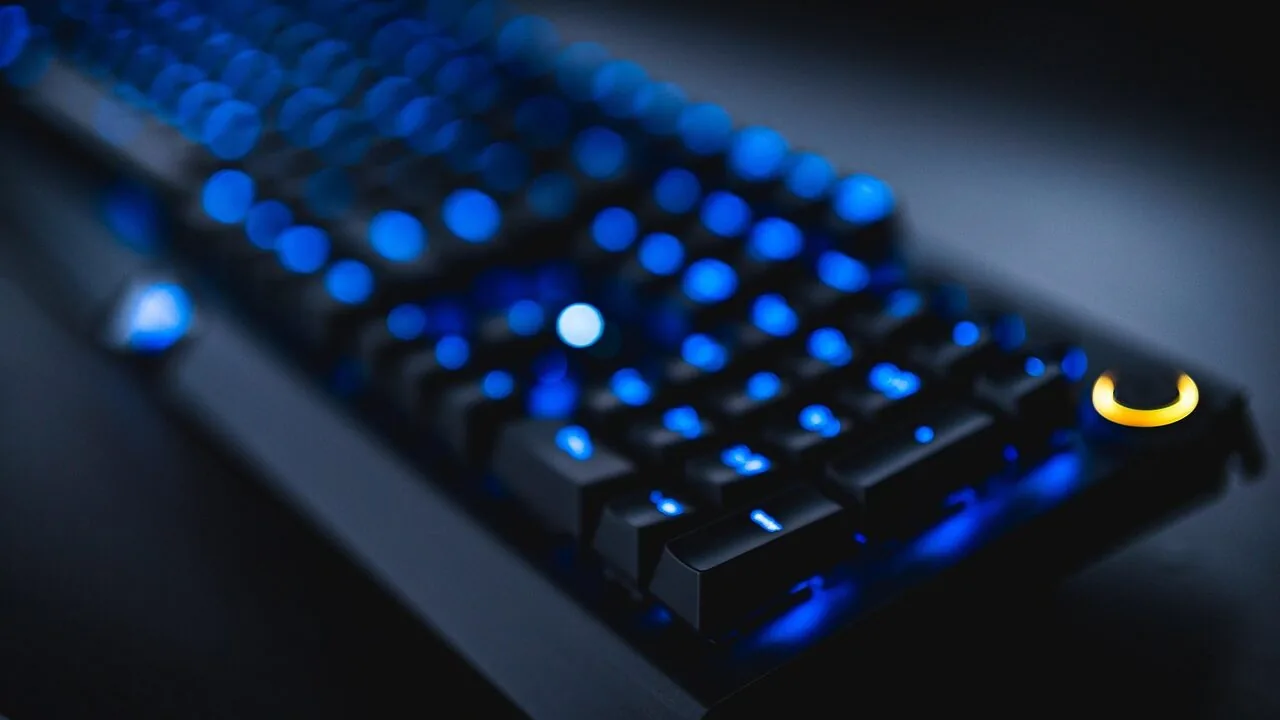 Gaming laptop displayed on desk with illuminated keyboard and screen showing game graphics