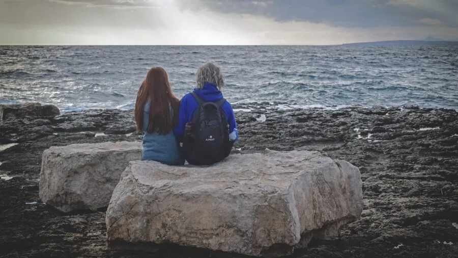Group of friends relaxing outdoors while listening to music in a natural setting