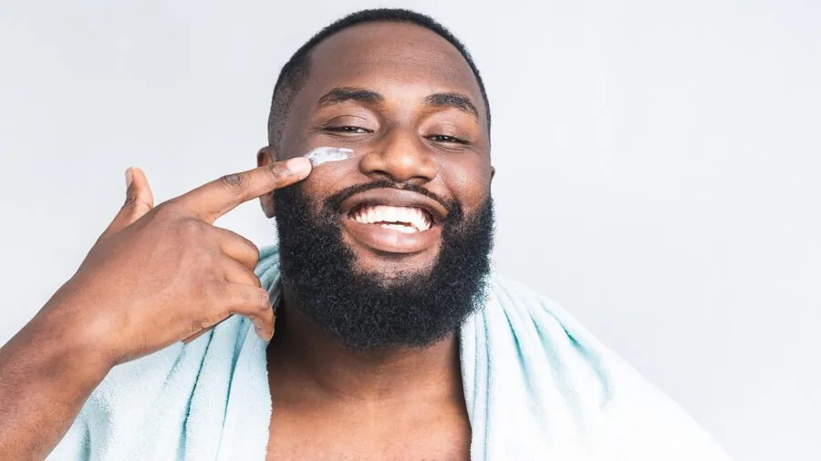 Man performing morning grooming routine in modern bathroom with natural light