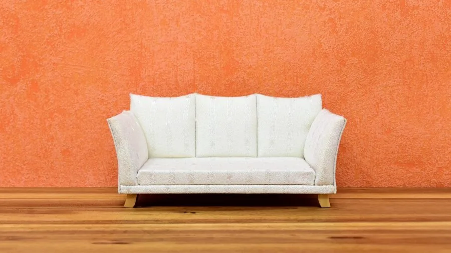 Person assembling wooden furniture with tools and instruction manual in bright living room