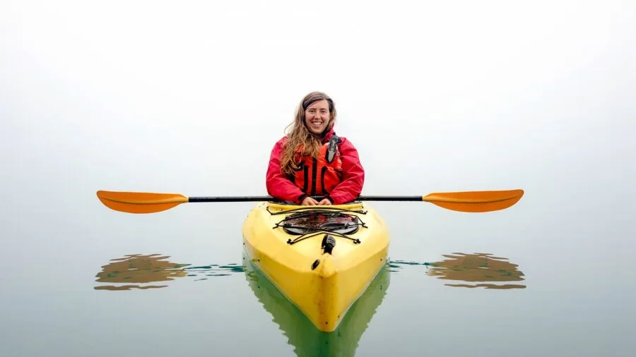Person filming scenic landscape with portable camera during outdoor adventure activity