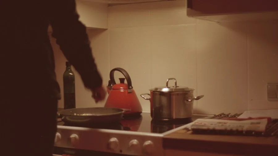 Person safely handling kitchen appliance with protective awareness in modern kitchen setting