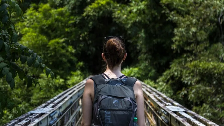 Person wearing a stylish backpack while traveling outdoors in natural daylight