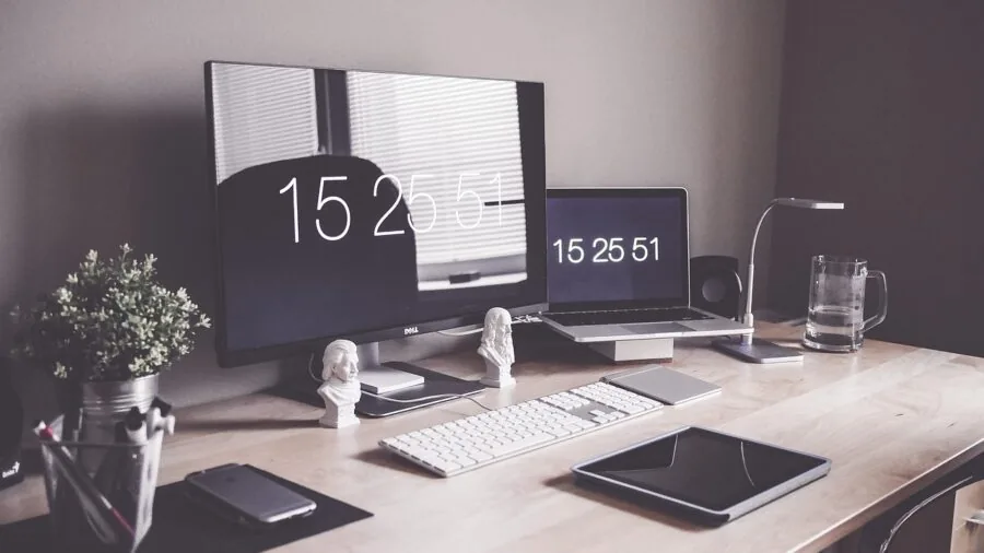 Person working at desk with computer tower and monitor in home office environment