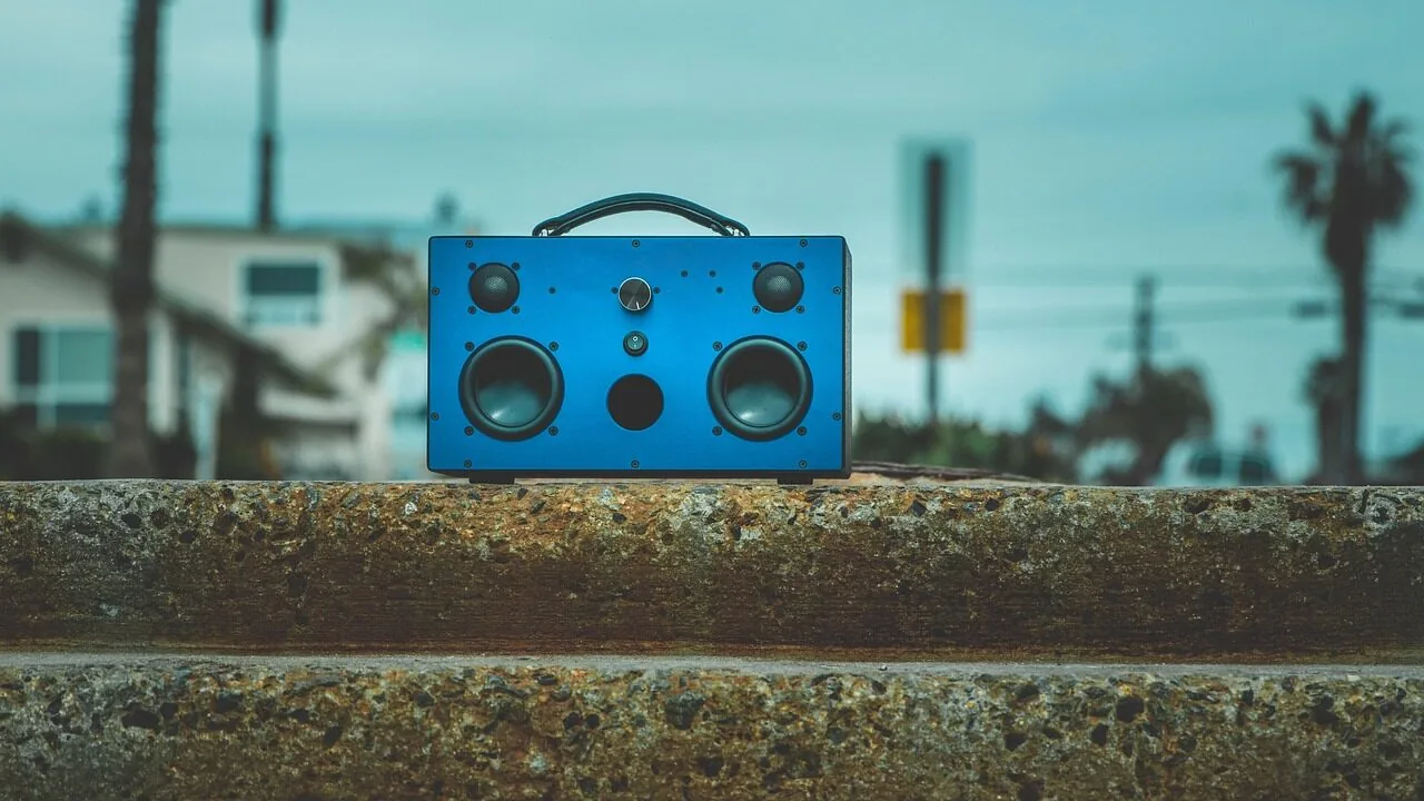 Portable Bluetooth speaker displayed on wooden table with natural lighting