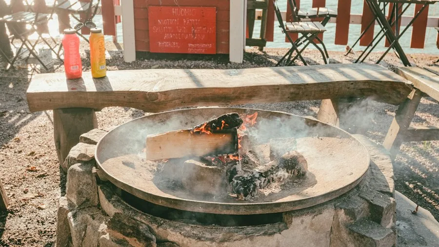Rustic fire pit with weathered metal construction in outdoor backyard setting during evening