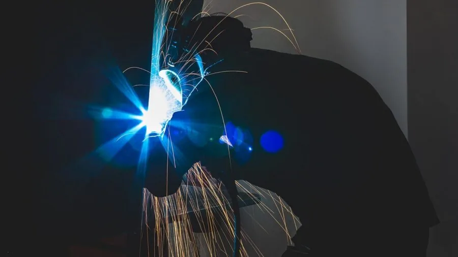 Technician performing maintenance on industrial equipment in a workshop setting